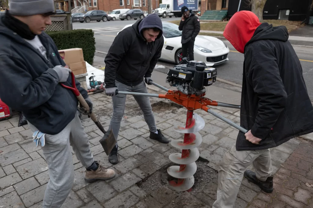 employees installing bollards in driveway